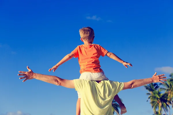 Gelukkig vader en zoontje op schouders spelen op strand — Stockfoto