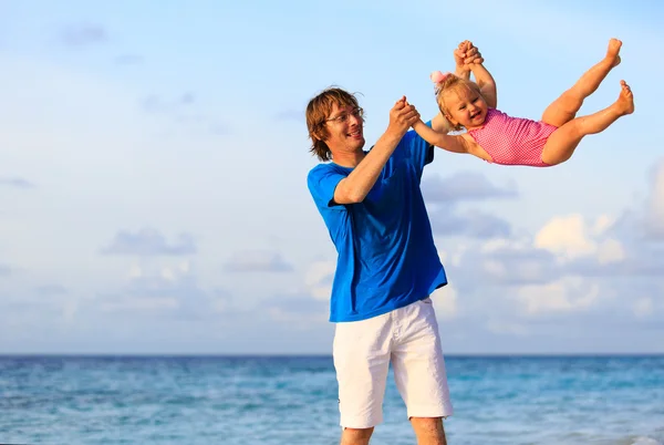 Отец и маленькая дочь веселятся на пляже — стоковое фото
