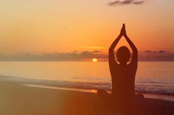 年轻人做瑜伽在日落时的剪影 — 图库照片