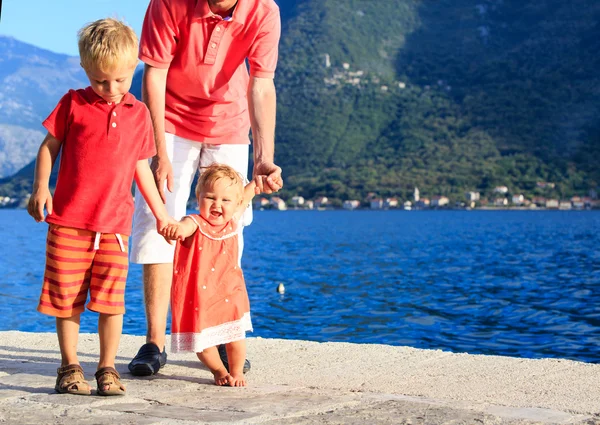 Familia con la pequeña hija aprendiendo a caminar en el mar — Foto de Stock