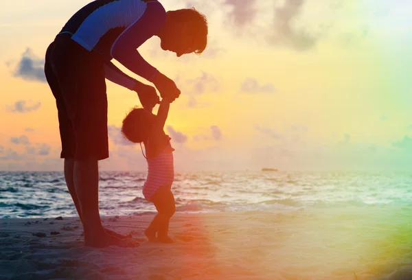 Père et petite fille marchant sur la plage du coucher du soleil — Photo