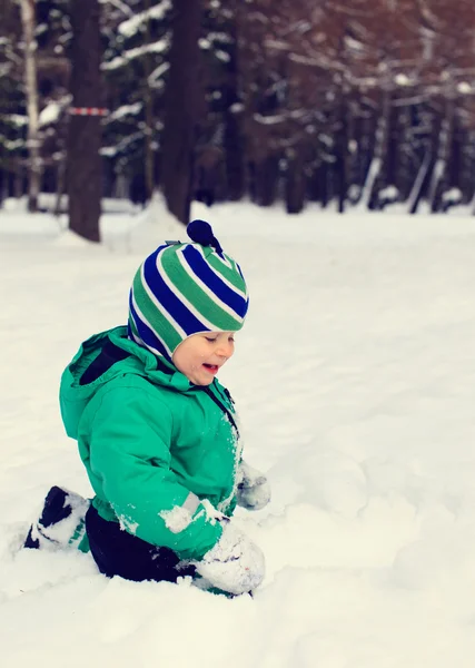 Kleiner Junge spielt mit Winterschnee — Stockfoto