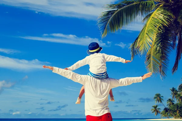 Батько і маленький син грають на небі на тропічному пляжі — стокове фото