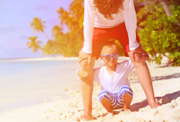 Raccolta e piccolo figlio che gioca sulla spiaggia estiva — Foto Stock