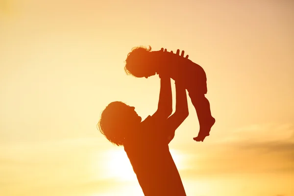 Pai e pequena filha silhuetas ao pôr do sol — Fotografia de Stock