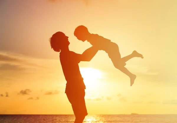Padre e figlio silhouette giocare al tramonto cielo — Foto Stock