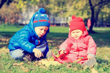 Sonbahar yaprakları ile oynayan çocuklar