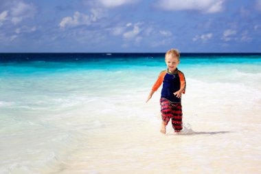 küçük çocuk kum plajı üzerinde çalışan