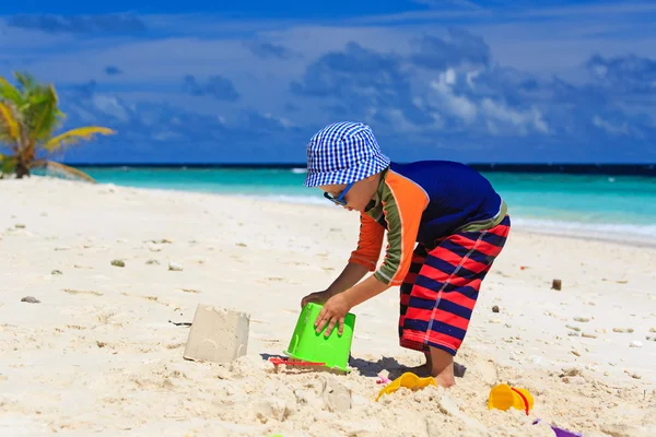Malý chlapec, hraní s pískem na tropické pláži — Stock fotografie