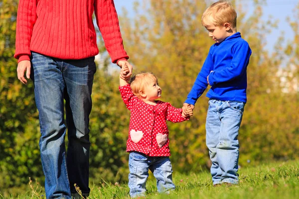 Padre con niños caminando en el parque de otoño — Foto de Stock