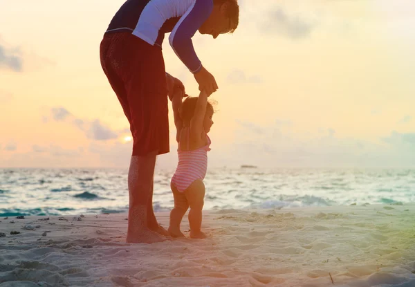 Père et petite fille marchant sur la plage du coucher du soleil — Photo