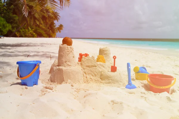 Hrad z písku na pláži a děti hračky — Stock fotografie
