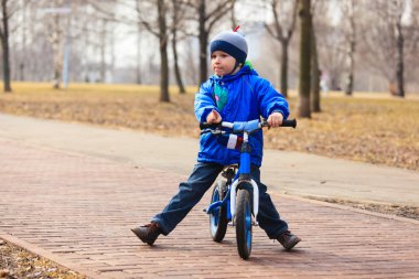 küçük çocuk Bisiklet sonbaharda çalıştırma
