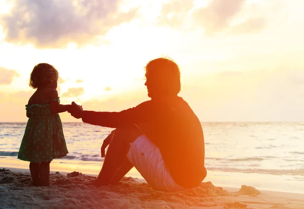 Père et petite fille se tenant la main au coucher du soleil — Photo