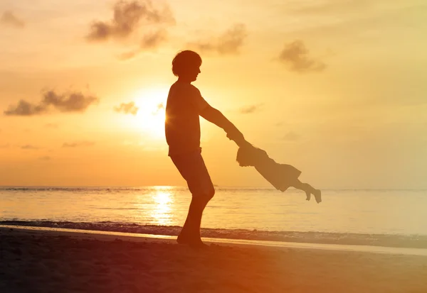 Père et petite fille jouent aux silhouettes au coucher du soleil — Photo