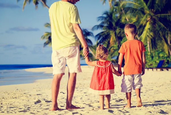 父亲和两个孩子在沙滩上行走 — 图库照片