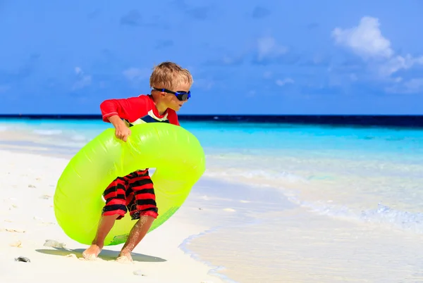 Bambino che gioca con l'anello di vita sulla spiaggia tropicale — Foto Stock