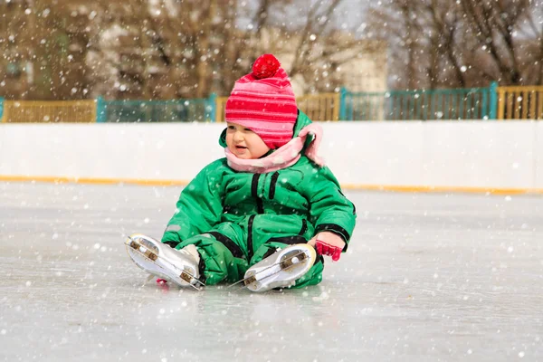 Little girl sitting on ice with skates after the fall — Φωτογραφία Αρχείου
