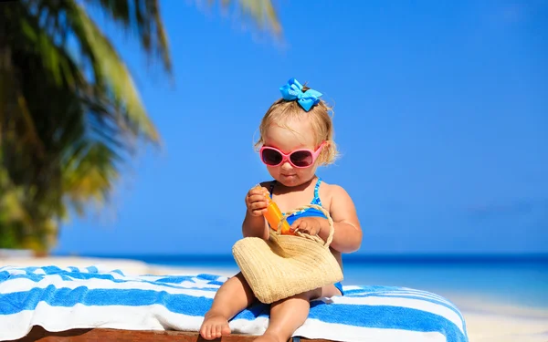 Schattig klein meisje met sunblock crème op strand — Stockfoto