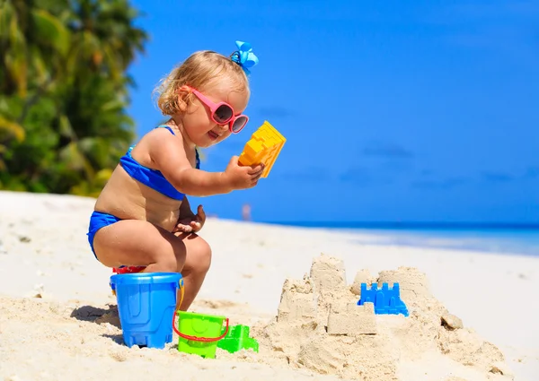 Cute dziewczynka budynku zamek z piasku na plaży — Zdjęcie stockowe