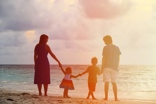 Familia feliz con dos niños en la playa del atardecer — Foto de Stock