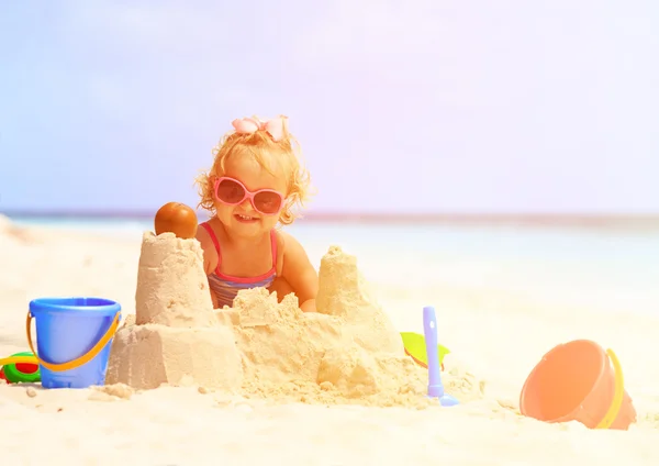 Schattig klein meisje spelen met zand op het strand — Stockfoto