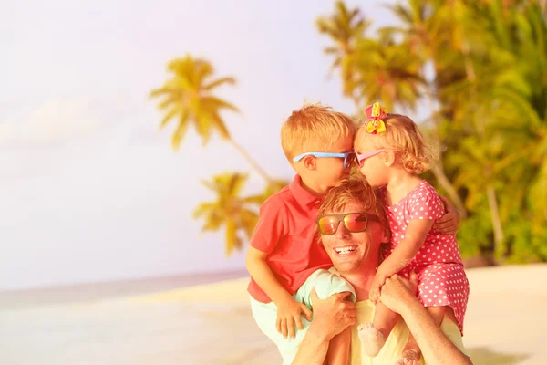 Szczęśliwy ojciec z dwójką dzieci na ramionach, zabawy na plaży — Zdjęcie stockowe