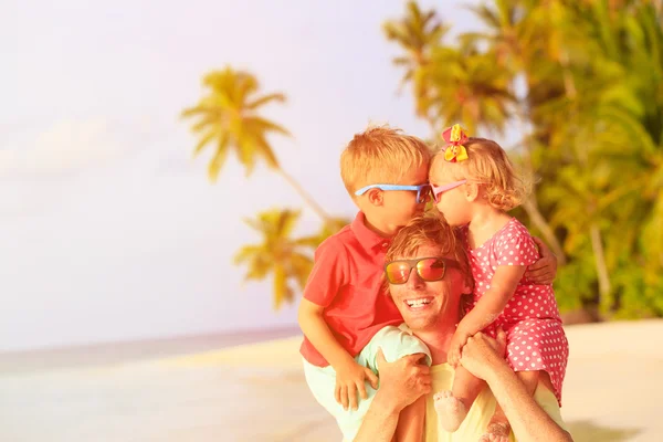 Père heureux avec deux enfants sur les épaules s'amuser à la plage — Photo