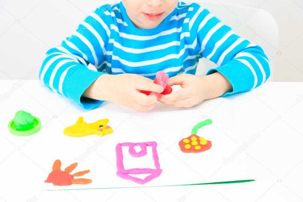 little boy playing with clay dough, education and daycare