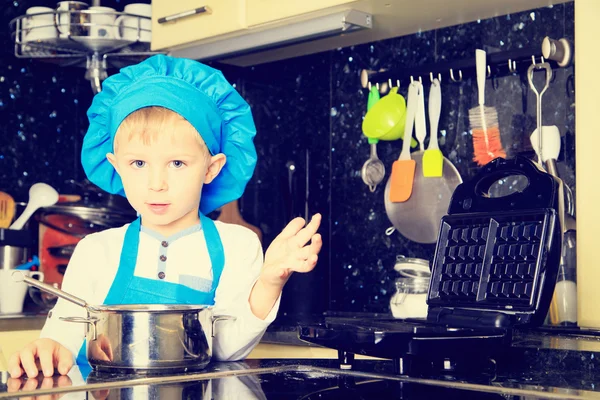 Menino gosta de cozinhar na cozinha — Fotografia de Stock