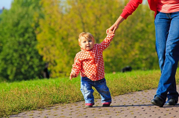 Primeros pasos de linda niña en el parque — Foto de Stock