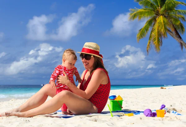 Mother and little daughter playing on tropical beach — Stock Photo, Image