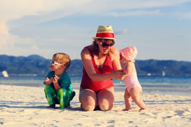 Kumsalda oynayan çocuklar ile anne