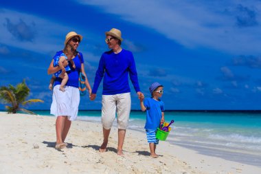 Aile çocuklarla kum plajda yürüyüş