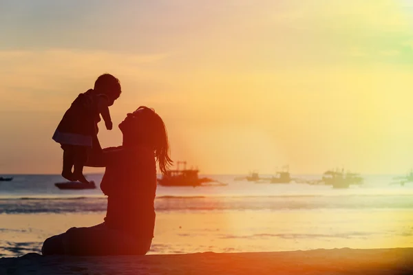 Felice madre e bambino al tramonto spiaggia — Foto Stock