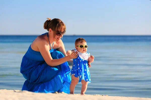 Мати навчає доньку ходити на пляжі — стокове фото