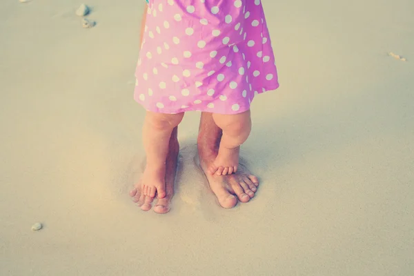 Padre e hija pequeña pies en una playa tropical — Foto de Stock