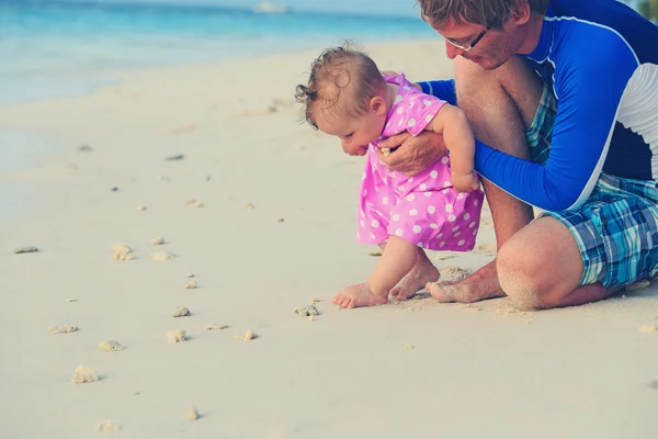 Padre y bebé tocando concha en la playa — Foto de Stock