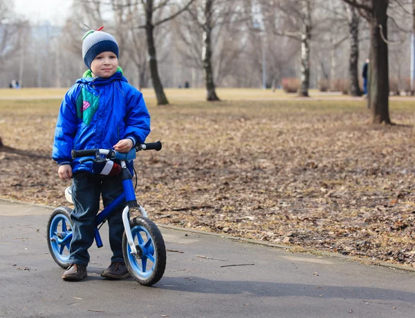 Маленький мальчик на беге на велосипеде осенью — стоковое фото