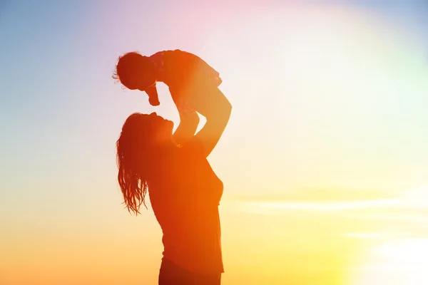 Mère heureuse et bébé s'amuser à la plage du coucher du soleil — Photo