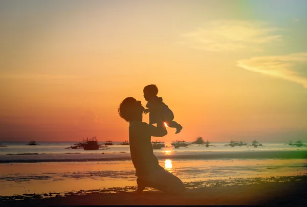 Silhouettes père et petite fille sur la plage du coucher du soleil — Photo