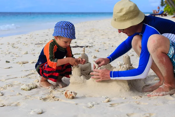 Otec a syn písku hrad na pláži — Stock fotografie