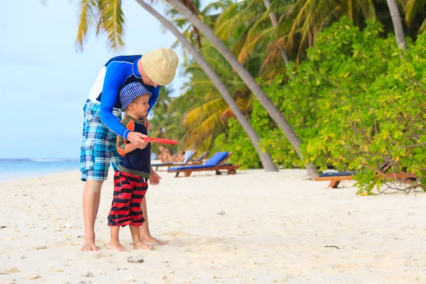 Otec a syn hraje s létající disk na pláži — Stock fotografie