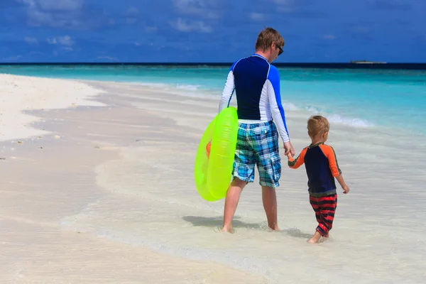 Батько і син йдуть плавати на пляжі — стокове фото