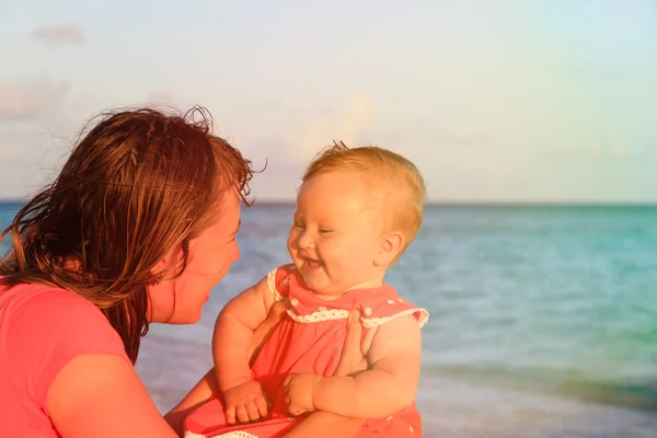 Moeder en kleine dochter plezier in sunset beach — Stockfoto