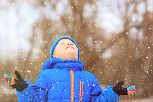 Liten pojke njuta av första snön i vinter natur — Stockfoto