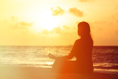 gün batımında yoga yaparken genç kadın