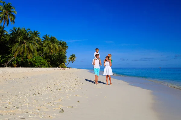 Giovane famiglia con due bambini che camminano in spiaggia — Foto Stock