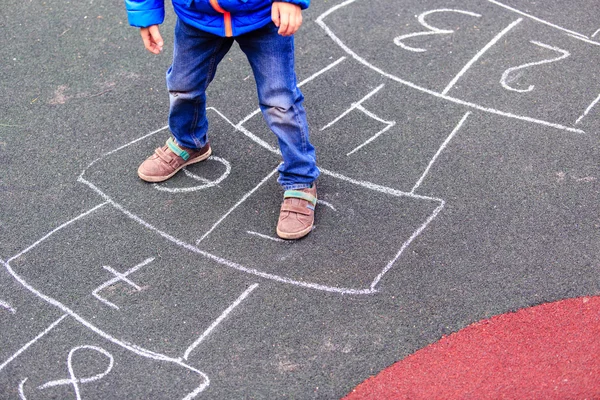 Criança jogando hopscotch no playground ao ar livre — Fotografia de Stock