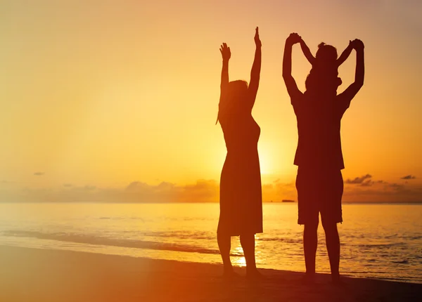 Famiglia felice con bambino che si diverte sulla spiaggia al tramonto — Foto Stock